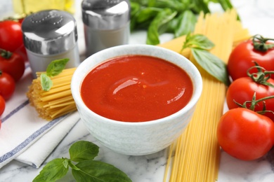 Bowl of tasty tomato sauce and pasta served on table
