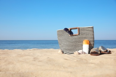 Photo of Stylish beach accessories on sandy sea shore