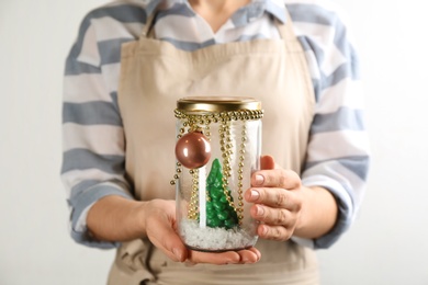 Woman holding handmade snow globe on white background, closeup