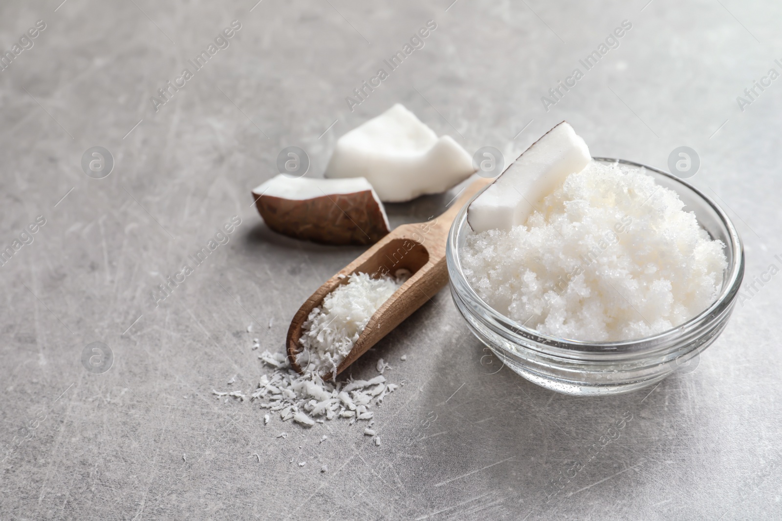 Photo of Glass bowl with natural coconut scrub on table