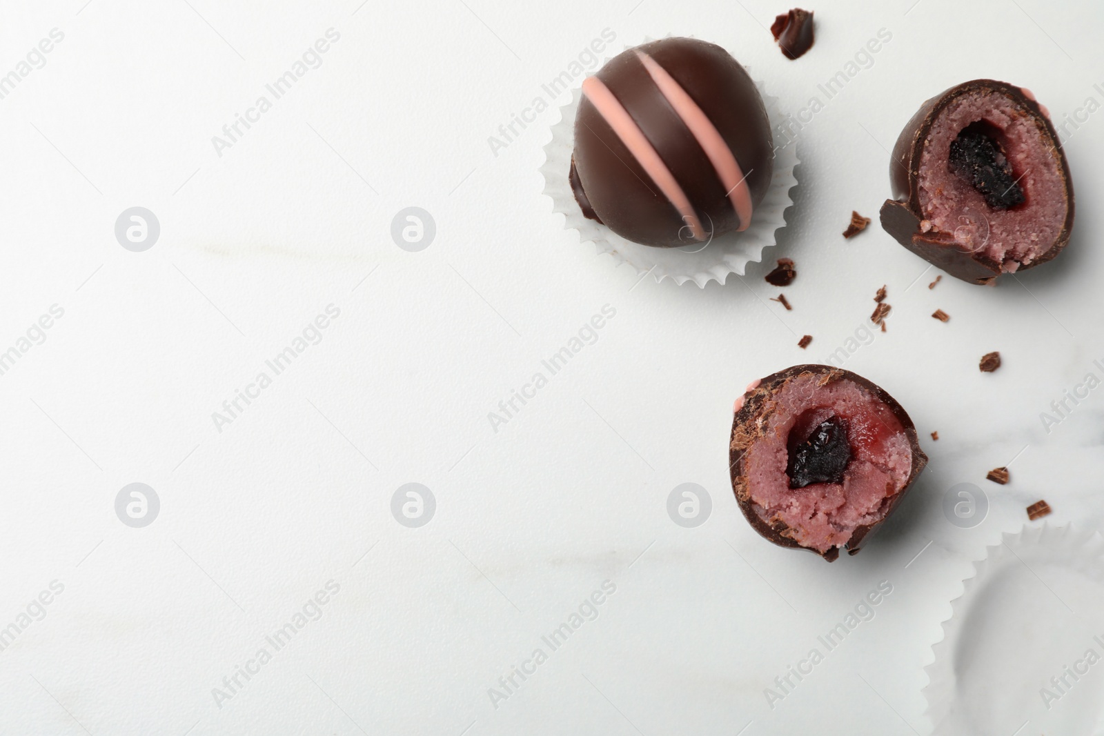 Photo of Different delicious chocolate truffles on white marble table, flat lay. Space for text