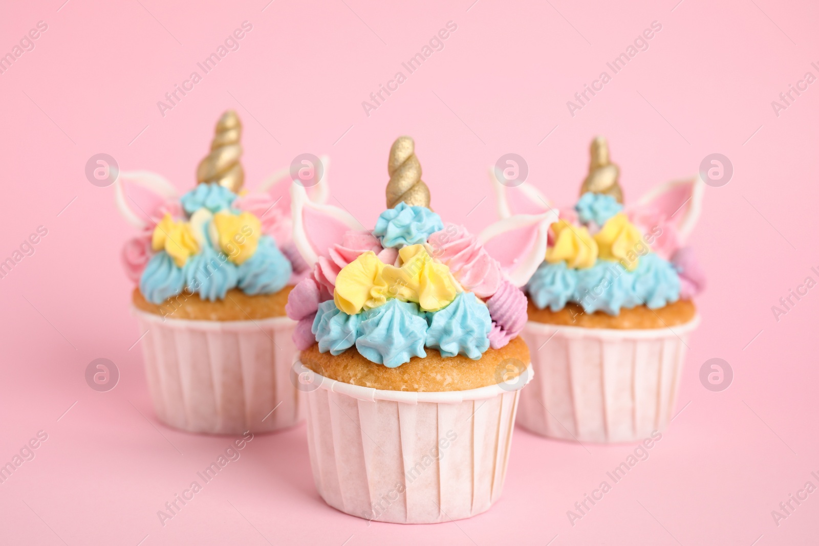 Photo of Cute sweet unicorn cupcakes on pink background