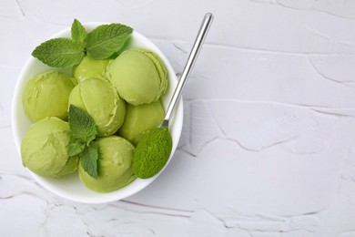 Photo of Tasty matcha ice cream and spoon with powder in bowl on white textured table, top view. Space for text