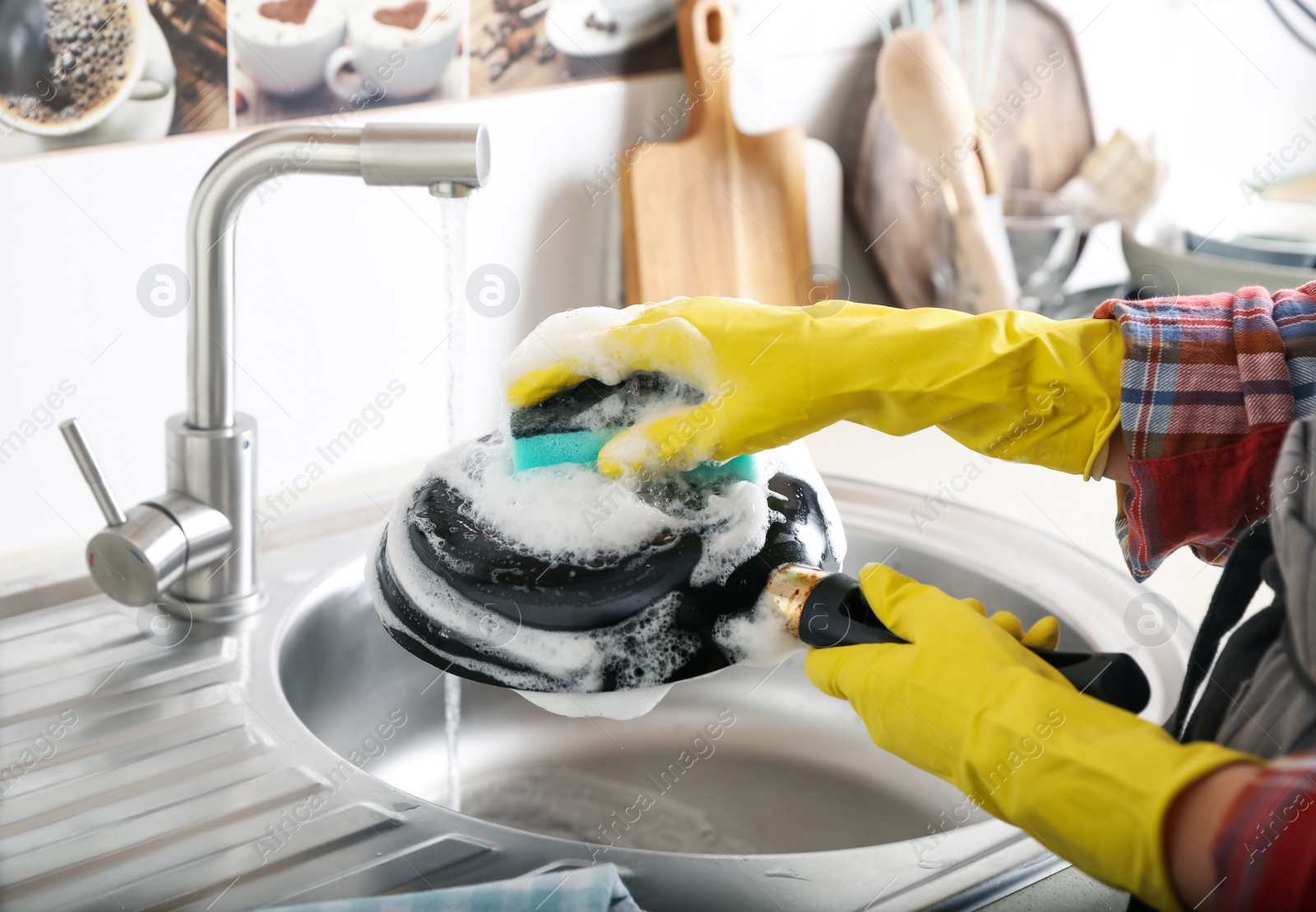 Photo of Woman washing dirty frying pan in sink indoors, closeup