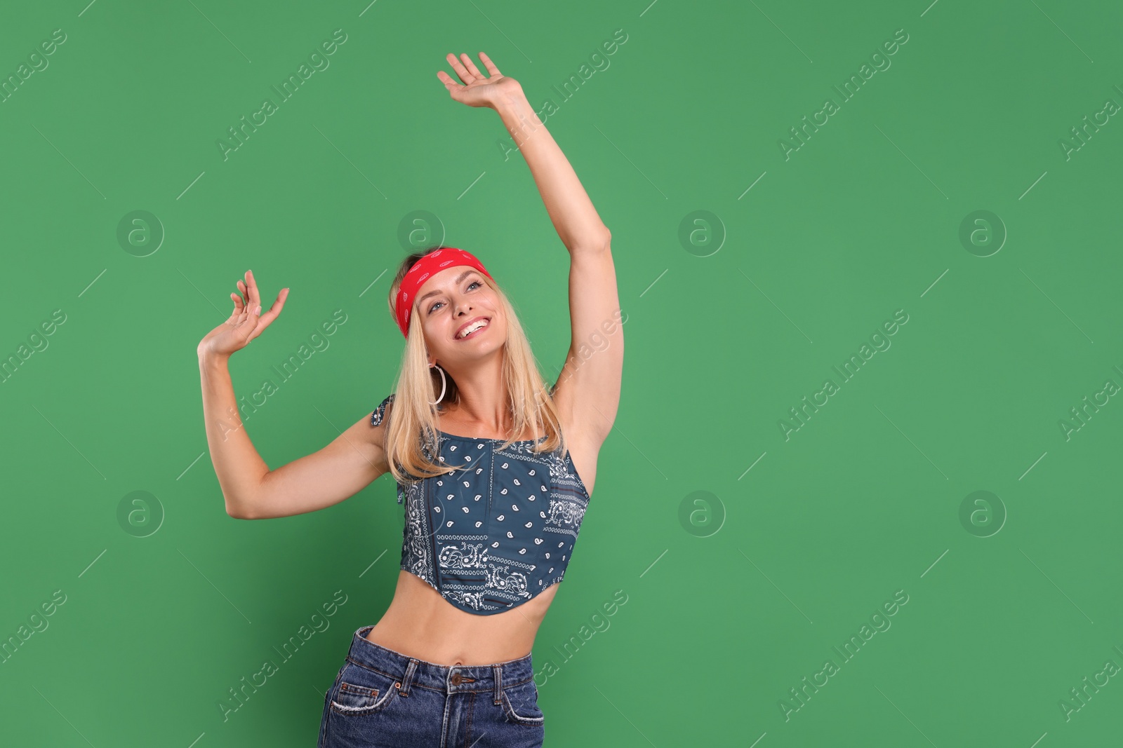 Photo of Portrait of happy hippie woman dancing on green background. Space for text