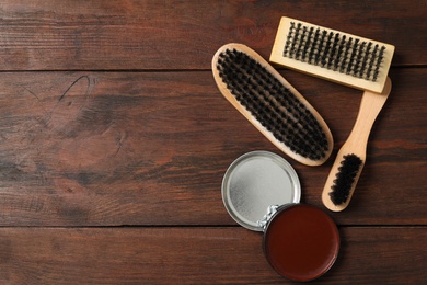 Flat lay composition with shoe care accessories on wooden background, space for text