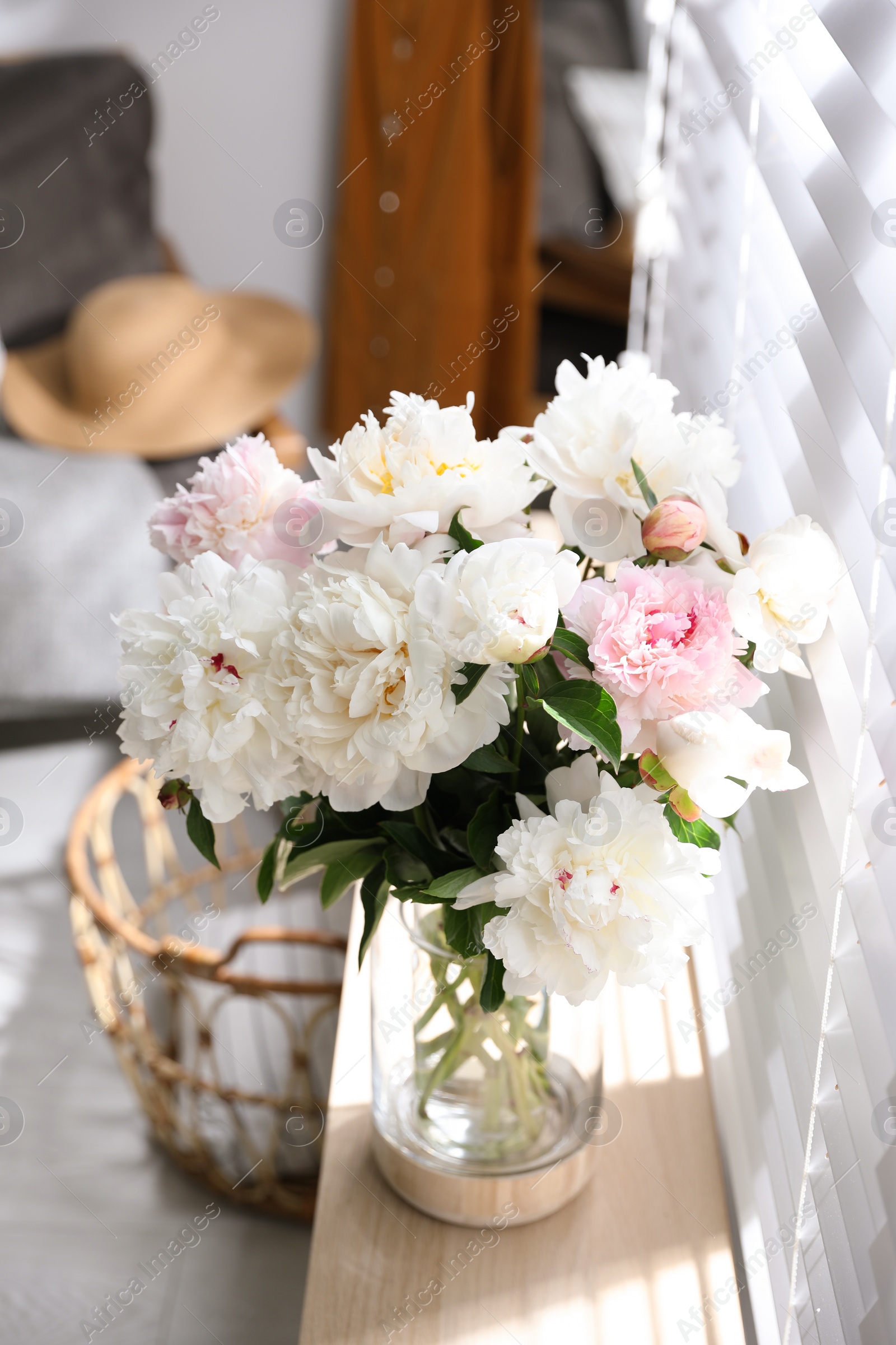 Photo of Bouquet of beautiful peony flowers on window sill indoors