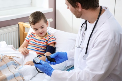 Photo of Doctor checking child's blood pressure in hospital