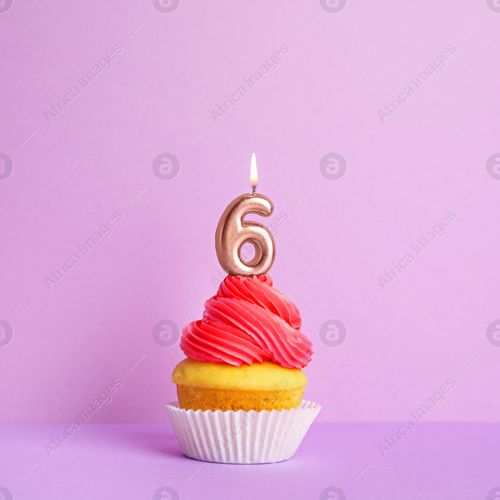 Photo of Birthday cupcake with number six candle on violet background