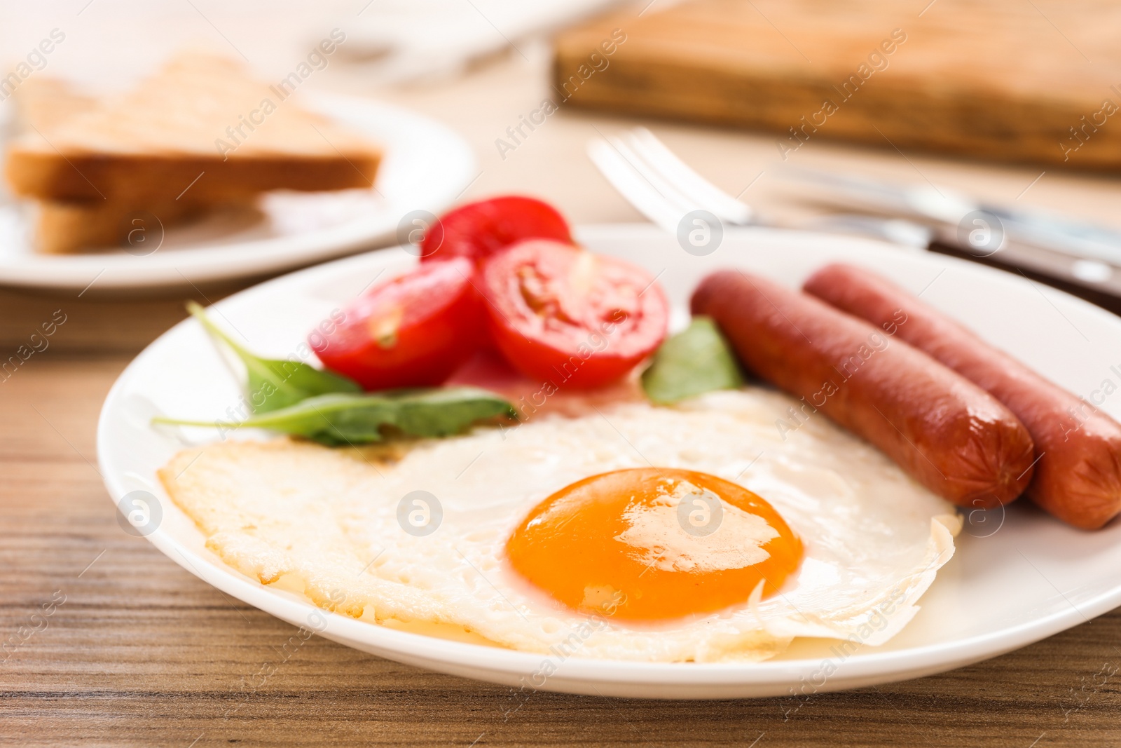 Photo of Tasty breakfast with fried egg on wooden table, closeup