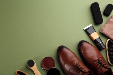 Flat lay composition with shoe care accessories and footwear on green background. Space for text