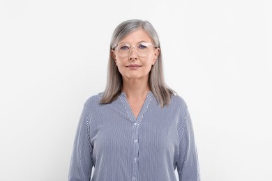 Portrait of beautiful senior woman in glasses on white background