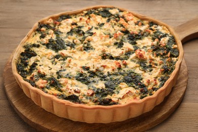 Photo of Delicious homemade spinach quiche on wooden table, closeup