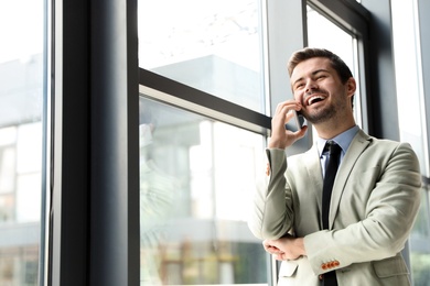 Male business trainer talking on phone in office