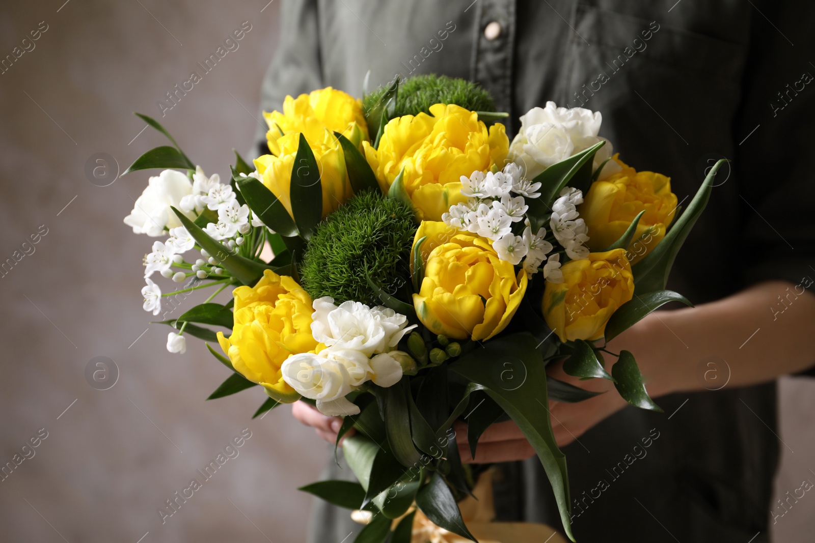 Photo of Woman with bouquet of beautiful peony tulips on beige background, closeup