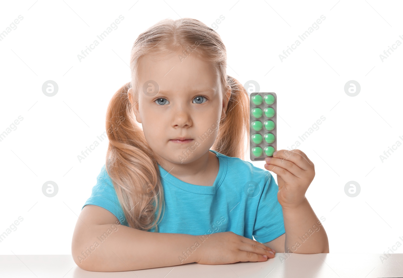 Photo of Little child with pills on white background. Danger of medicament intoxication