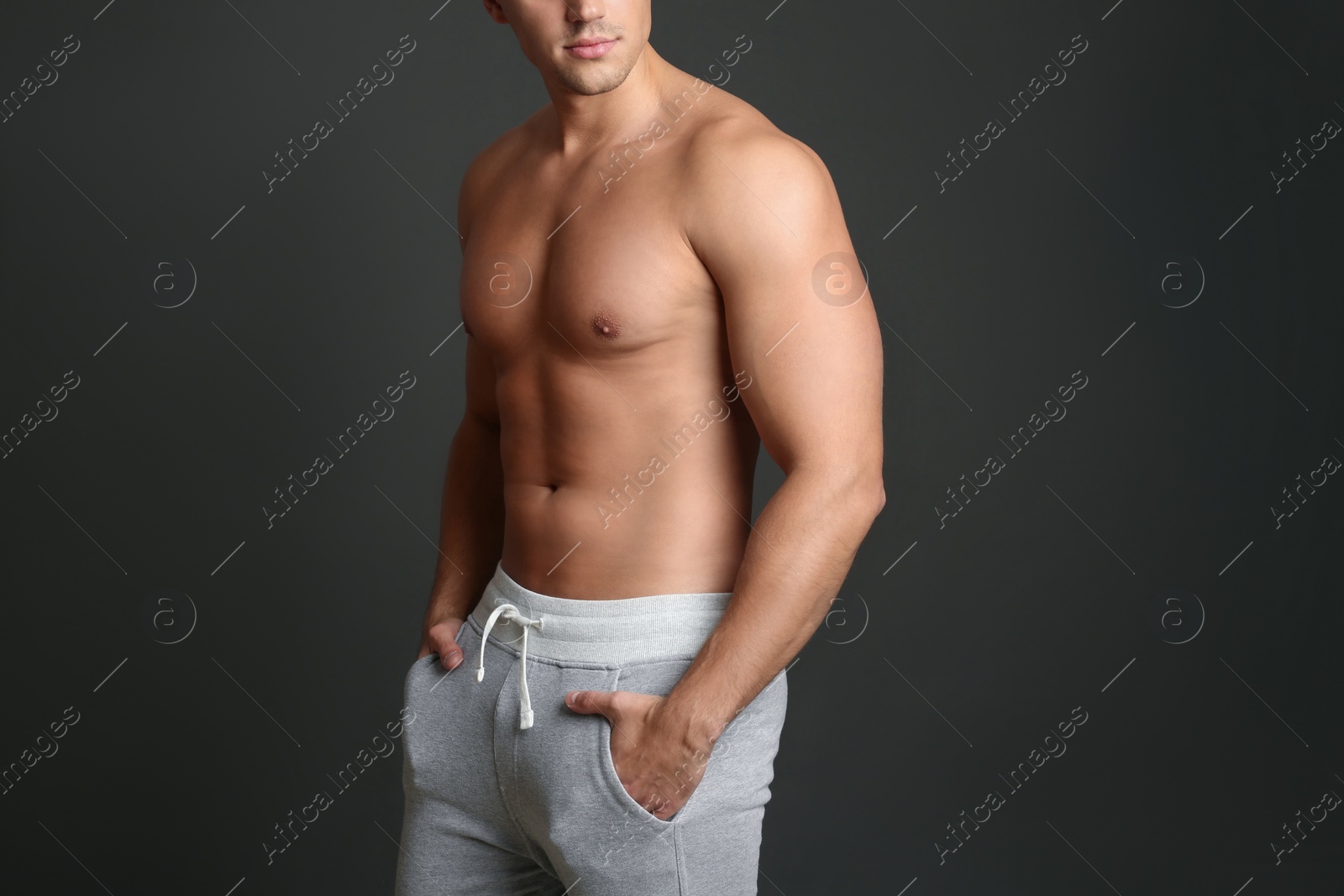 Photo of Man with sexy body on grey background, closeup