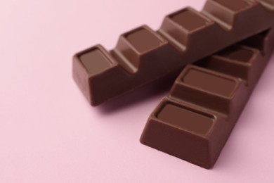 Photo of Delicious chocolate bars on pink background, closeup