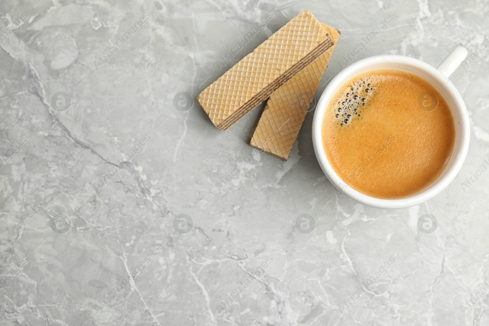 Photo of Breakfast with delicious wafers and coffee on grey marble table, flat lay. Space for text