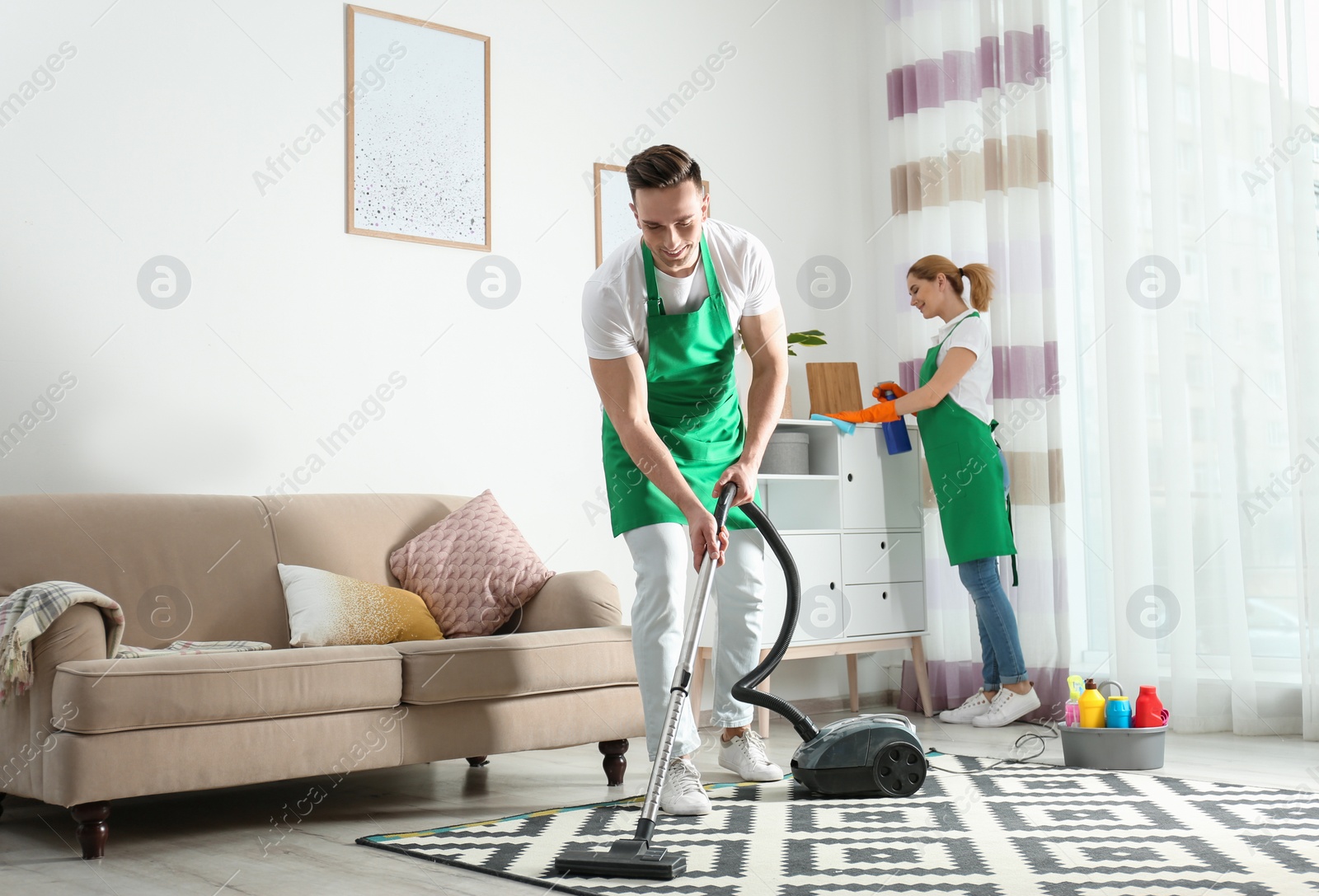 Photo of Cleaning service team at work in living room