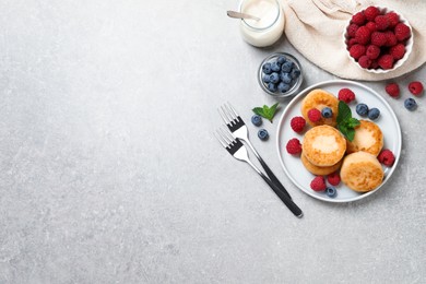 Delicious cottage cheese pancakes with berries on light table, flat lay. Space for text