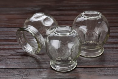 Glass cups on wooden table, closeup. Cupping therapy