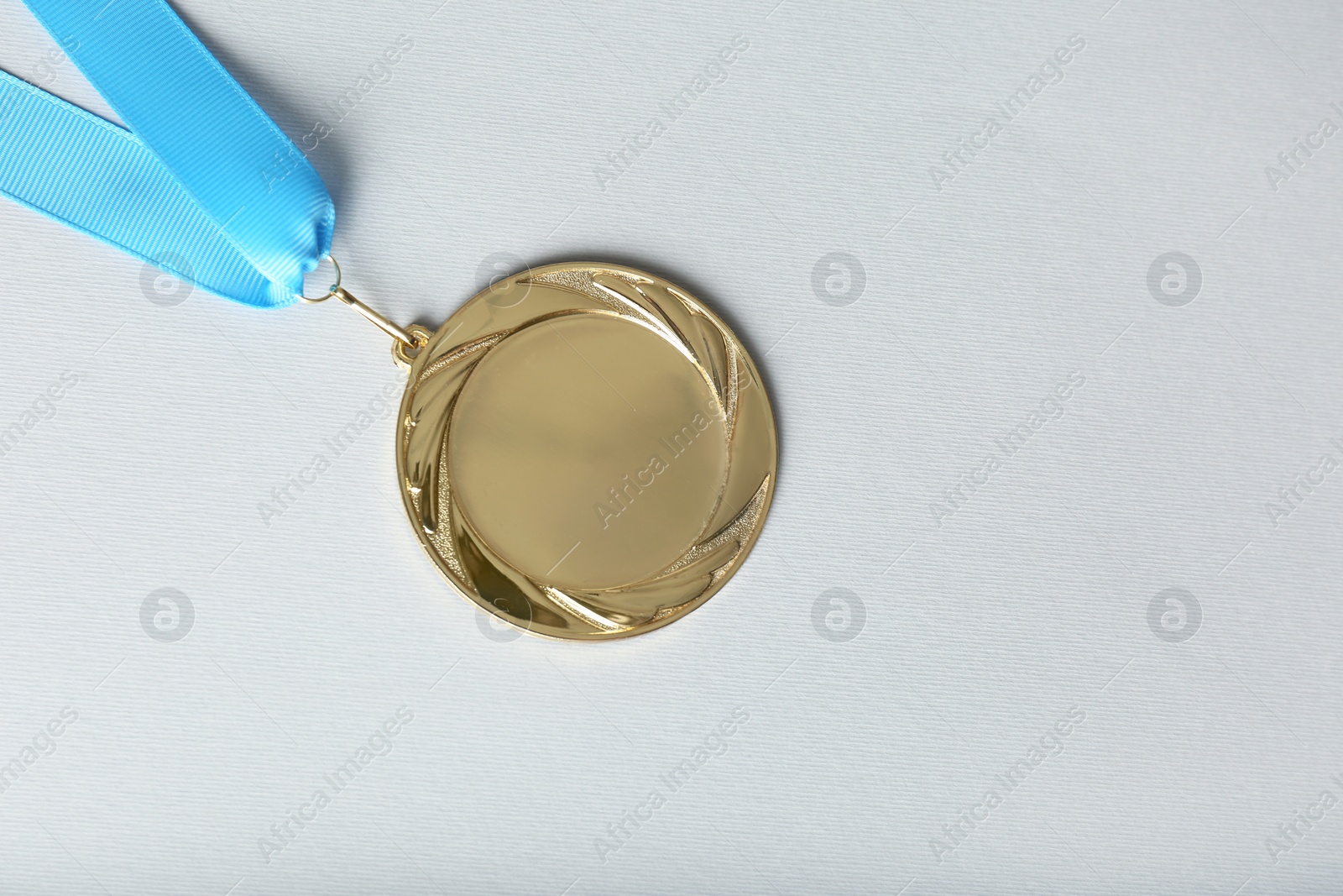 Photo of Gold medal on white background, top view. Space for design