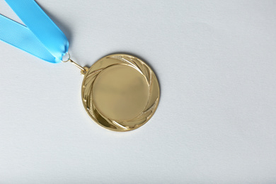 Photo of Gold medal on white background, top view. Space for design