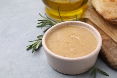 Photo of Delicious turkey gravy and rosemary on grey table, closeup. Space for text