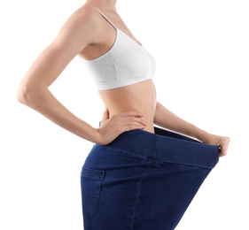 Photo of Young slim woman wearing oversized jeans on white background, closeup