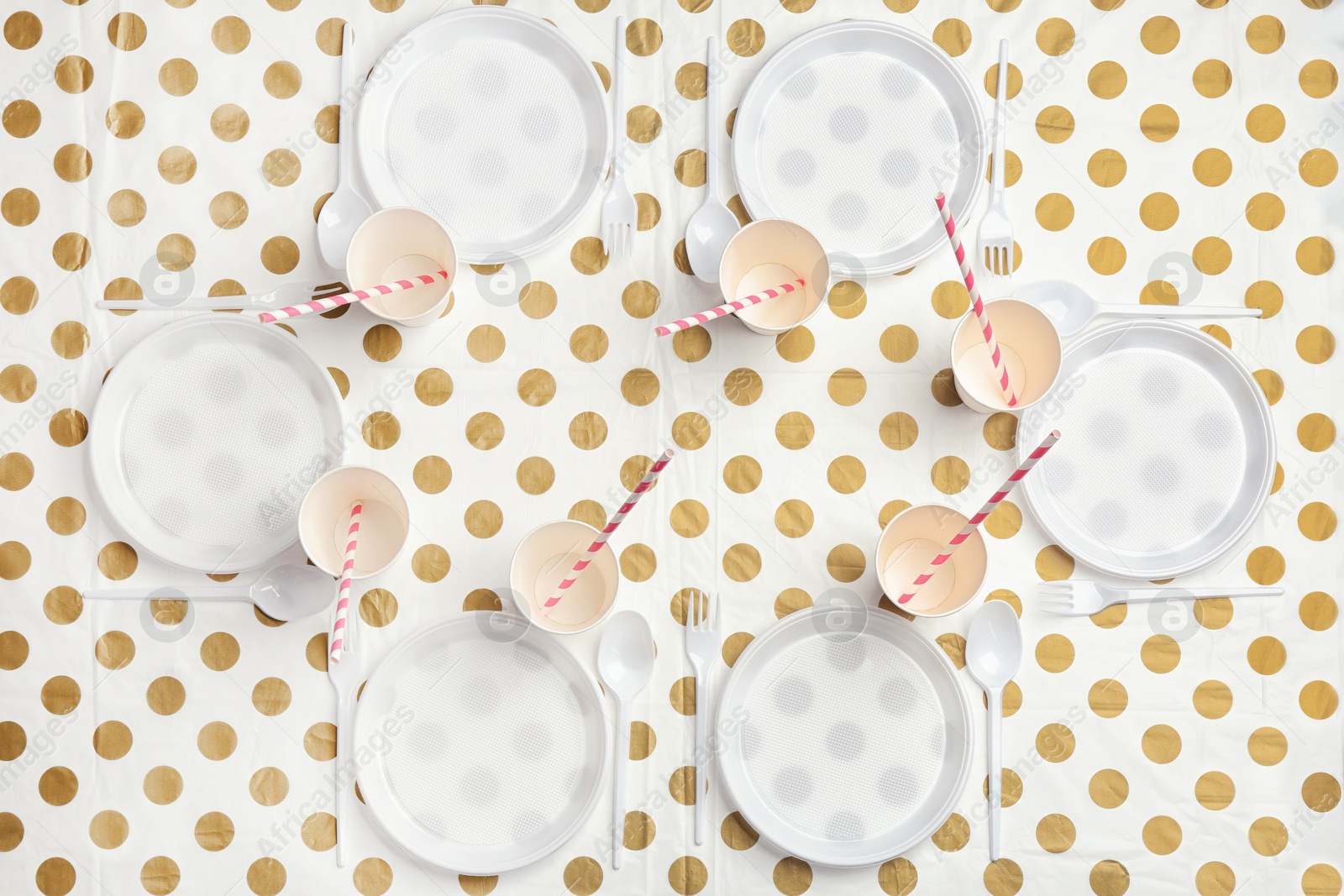 Photo of Table setting with plastic dishware on patterned background, top view