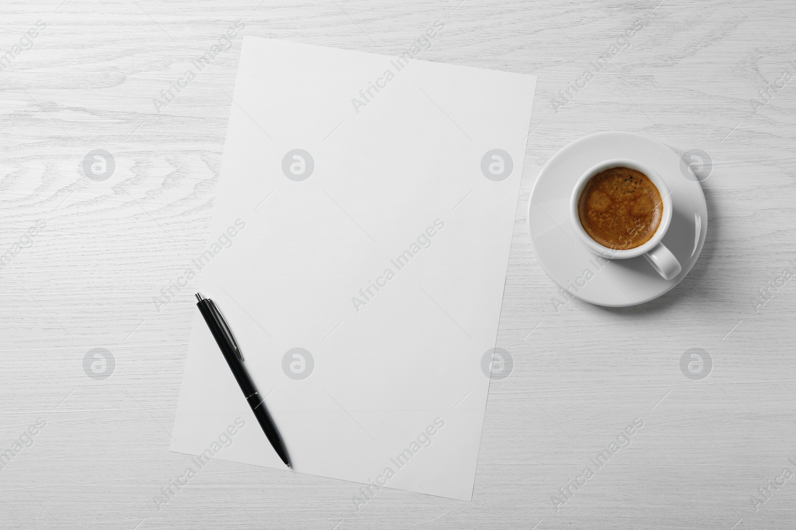 Photo of Blank paper sheet, pen and cup of coffee on white wooden table, flat lay. Space for text