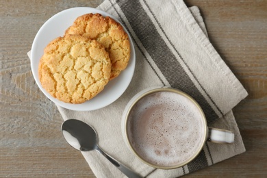 Composition with delicious hot cocoa drink and cookies on wooden background, flat lay