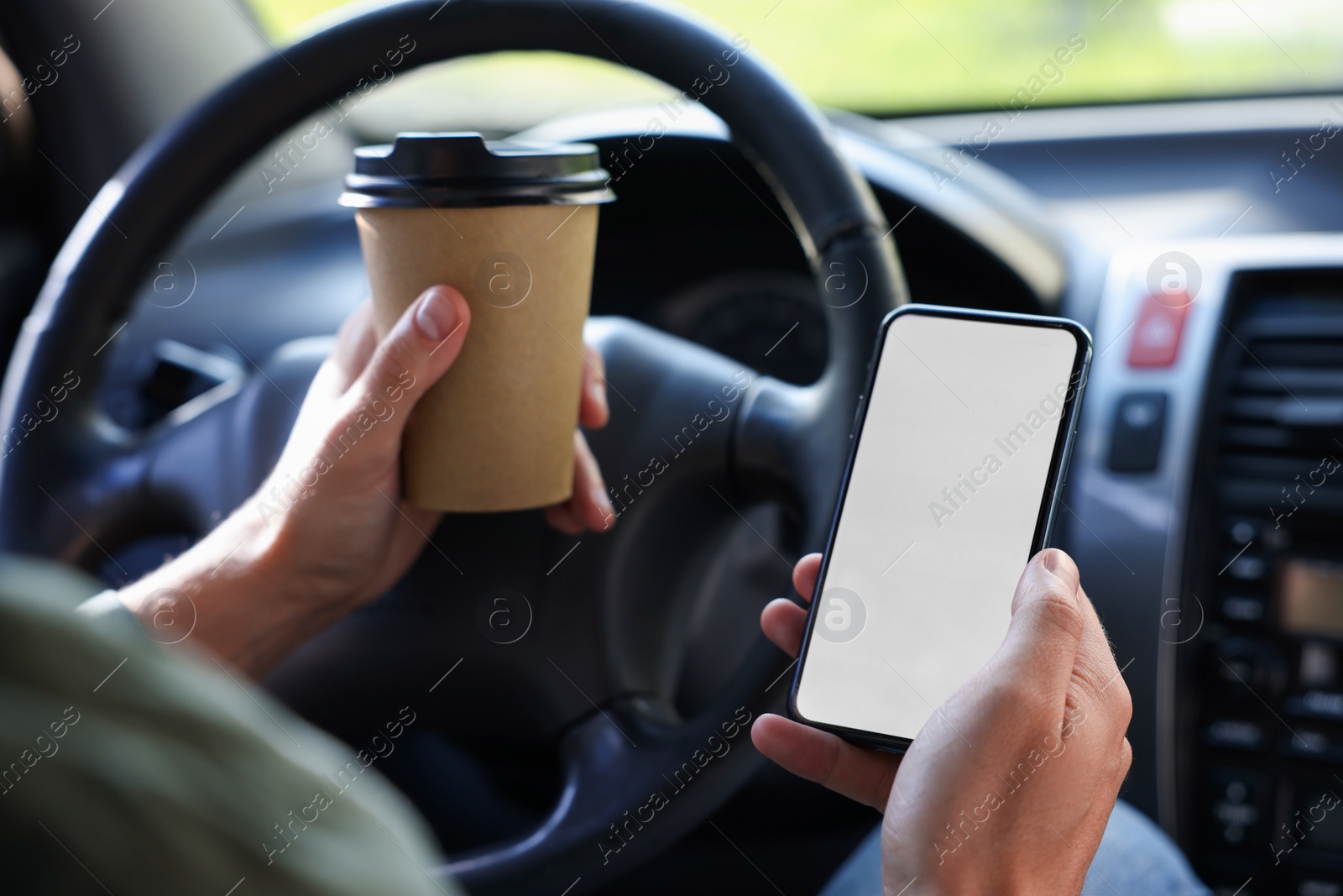 Photo of Coffee to go. Man with paper cup of drink and smartphone in car, closeup