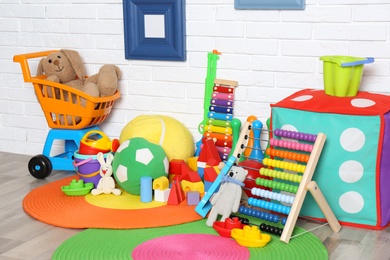 Different child toys on floor against brick wall