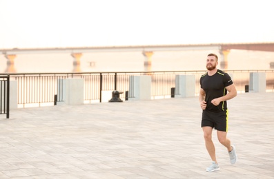 Young man running outdoors on sunny day