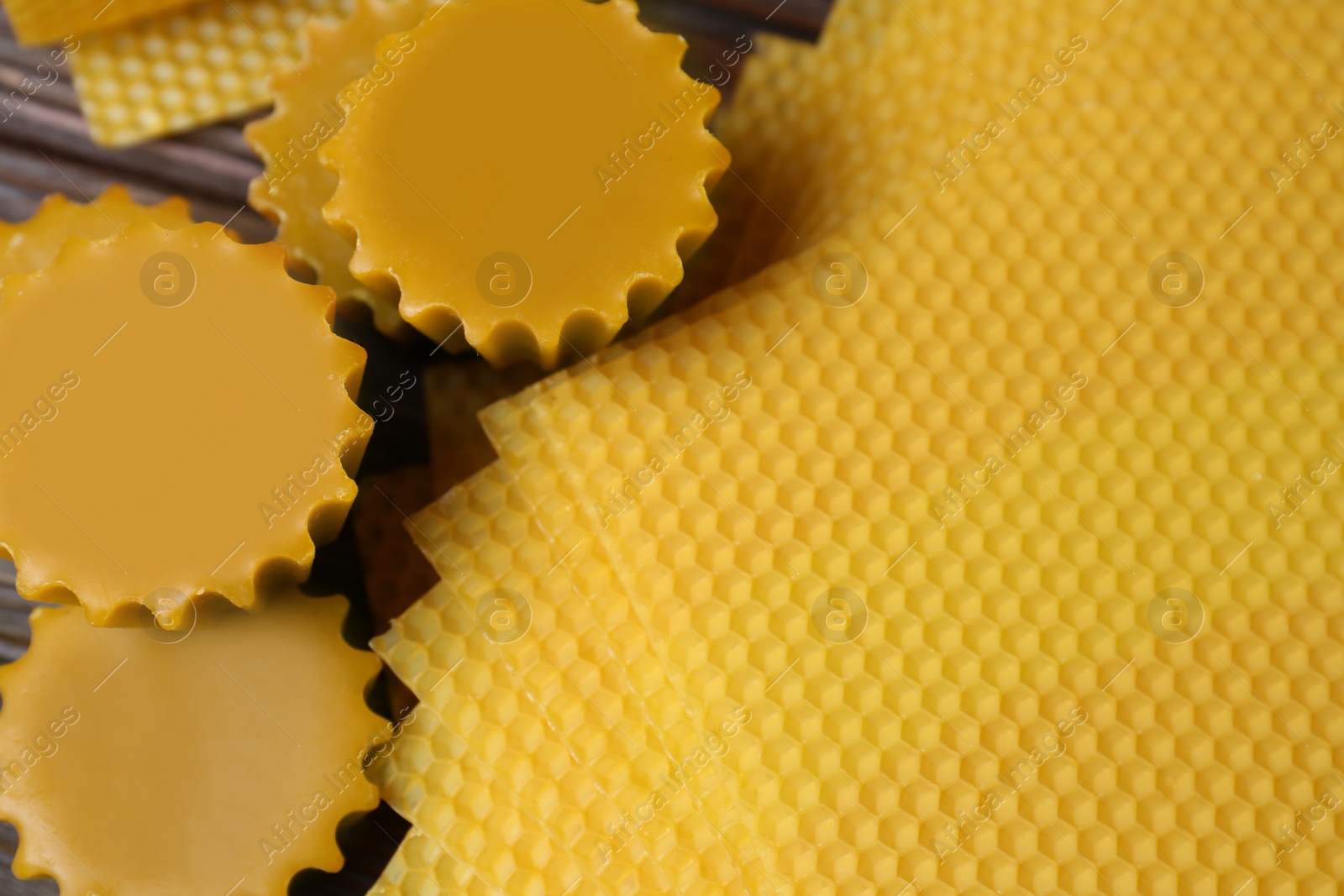 Photo of Natural beeswax cake blocks and sheets on wooden table, above view