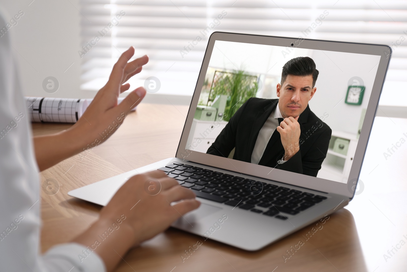 Image of Woman talking with handsome man using video chat on laptop at wooden table, closeup. Online dating