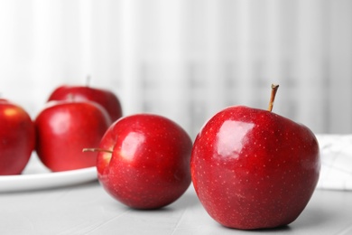 Photo of Ripe juicy red apples on light table indoors