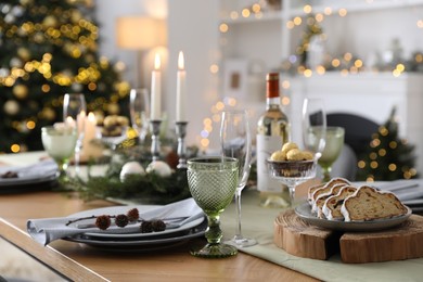 Photo of Christmas table setting with festive decor and dishware in room