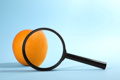 Photo of Cellulite problem. Zoomed orange peel on light blue background, view through magnifying glass. Space for text
