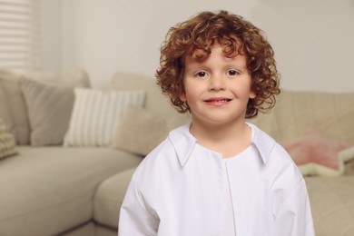 Portrait of little boy in medical uniform at home. Space for text