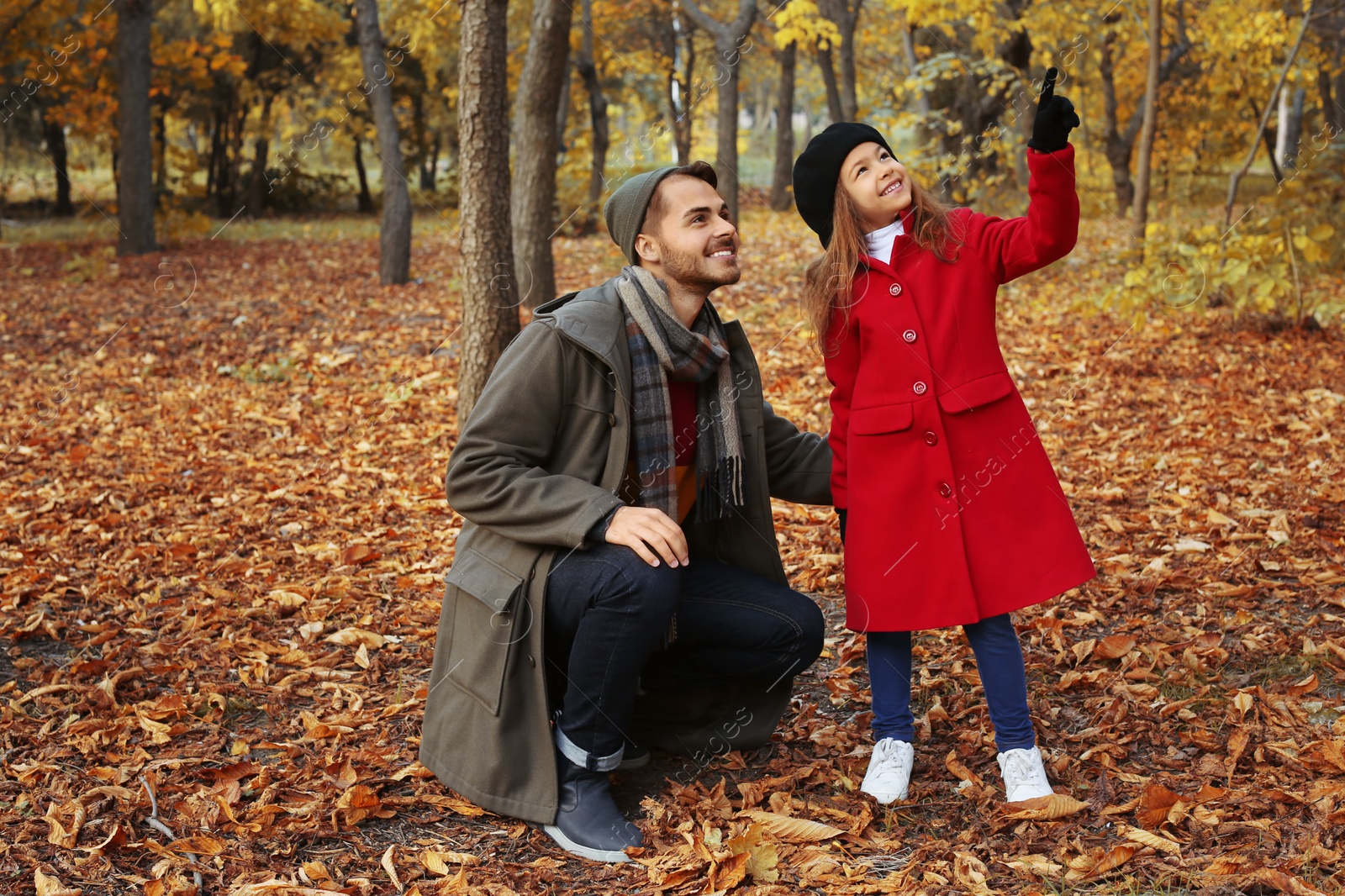 Photo of Father and his cute daughter spending time together in park. Autumn walk