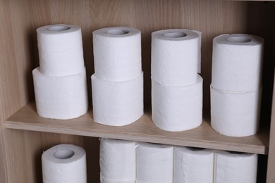 Photo of Stacked toilet paper rolls on wooden shelves