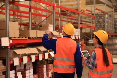 Manager and worker at warehouse, back view. Logistics center