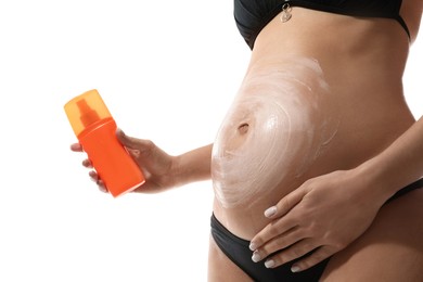 Pregnant woman applying sun protection cream on her belly against white background, closeup