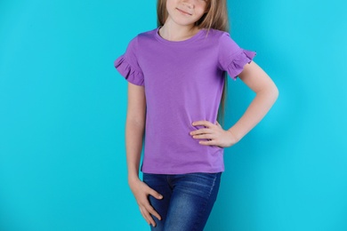 Photo of Little girl in t-shirt on color background. Mockup for design