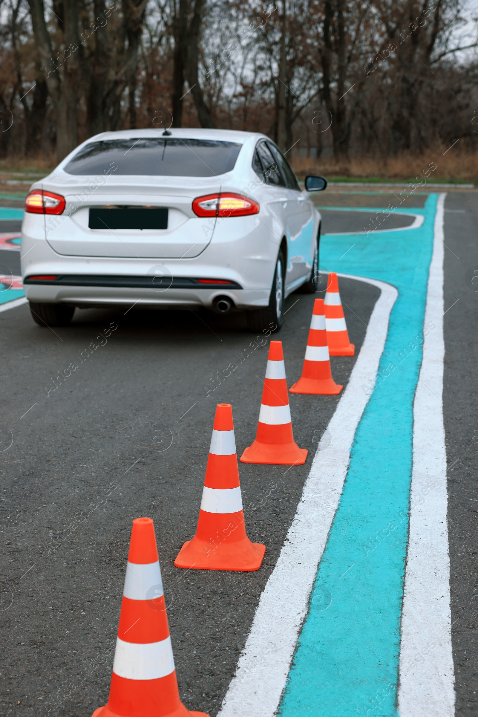 Photo of Modern car on driving school test track with traffic cones