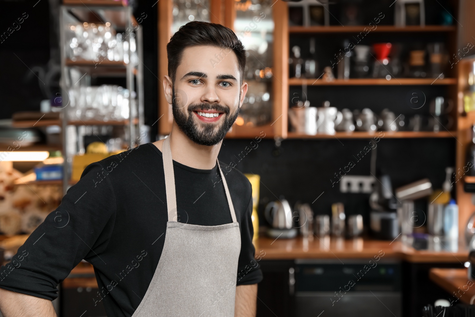 Photo of Portrait of smiling barista in coffee shop. Space for text