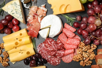 Photo of Flat lay composition with snacks for wine on black background